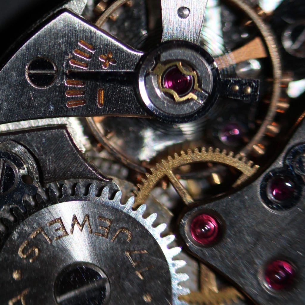 Image showcasing up-close image of watch wheel train and jewels