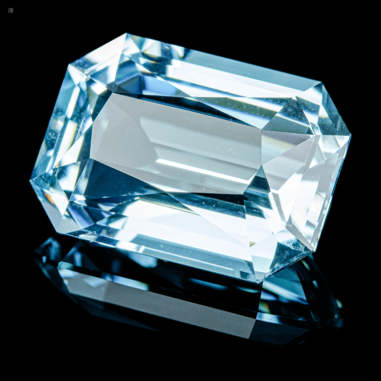 Cut and Polished Aquamarine Loose Gemstone Reflected Against Black Background