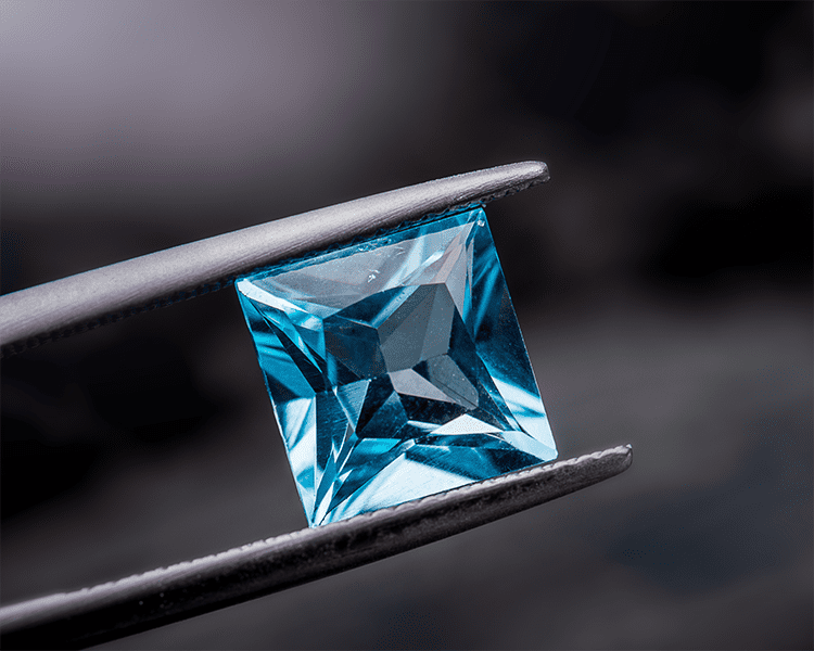 Loose Square Cut Aquamarine Gemstone Held with Jeweler's Tweezers