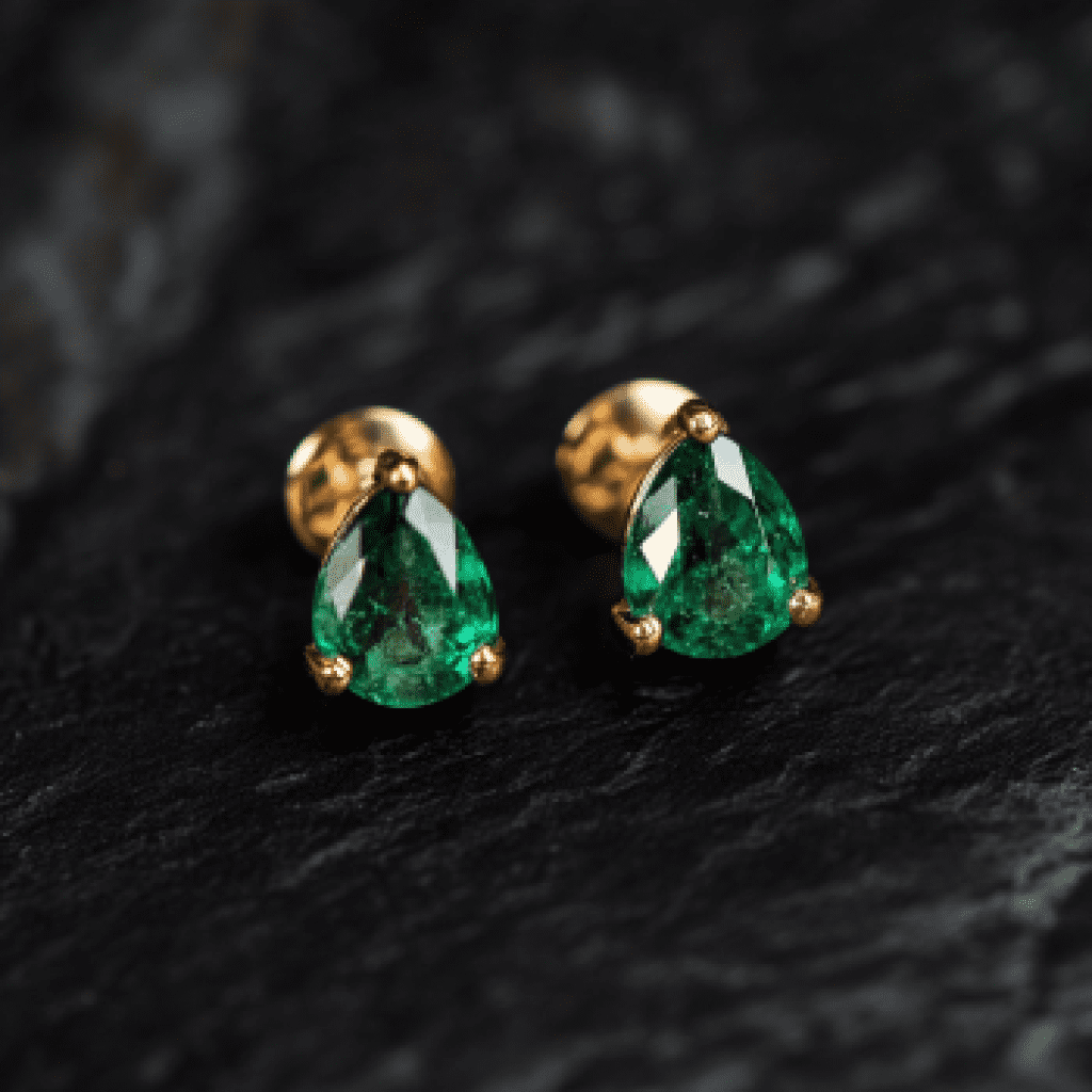 Image showcasing emerald earrings on black background