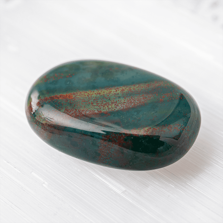 Polished Oval Green Heliotrope Bloodstone with Red Splatter Spots Displayed on White Tray
